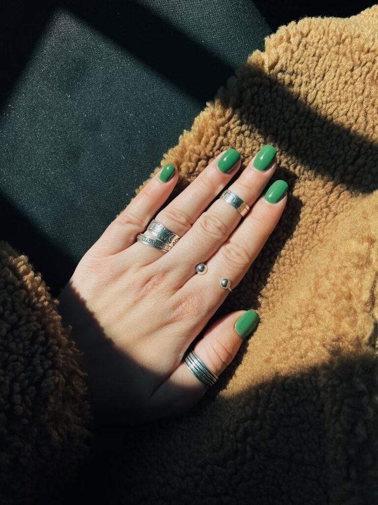 Hand of a woman with green nail polish